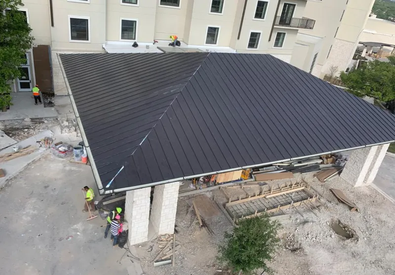 Metal roofing installation team working on a commercial building in Rowlett